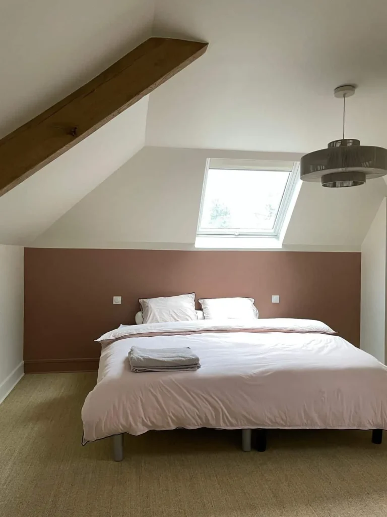 Chambre sous combles avec tête de lit peinte en vieux rose