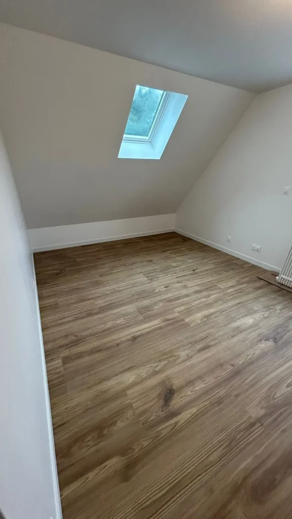 Chambre mansardée avec parquet chêne et fenêtre de toit