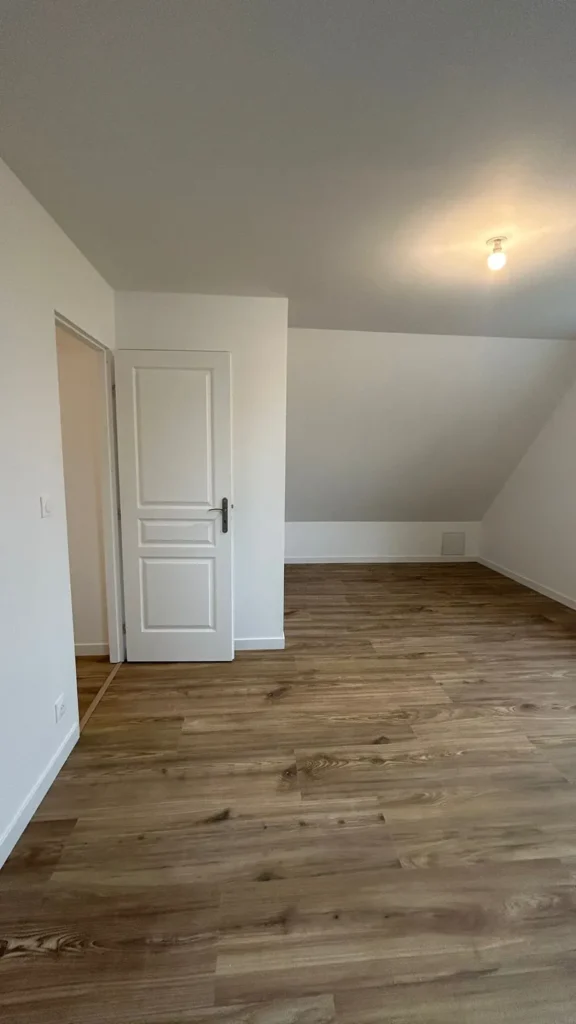 Chambre mansardée repeinte en blanc avec parquet