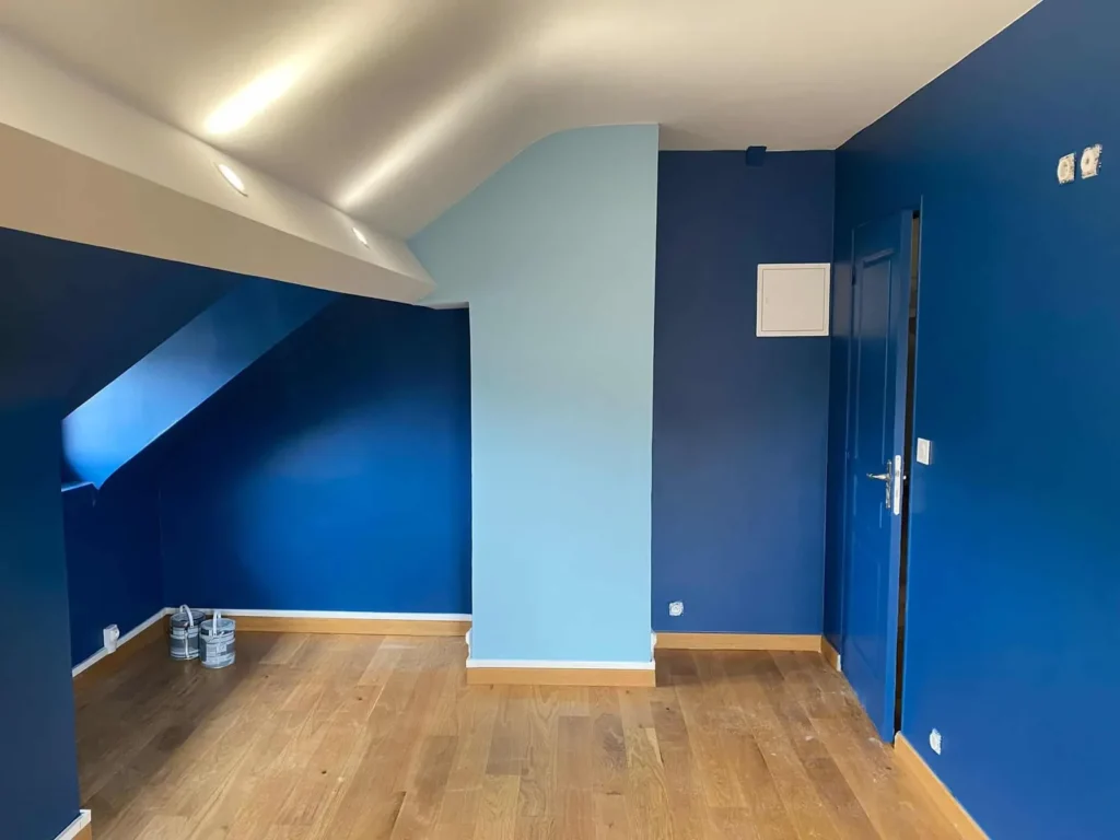 Chambre mansardée peinte en bleu roi et bleu clair avec parquet