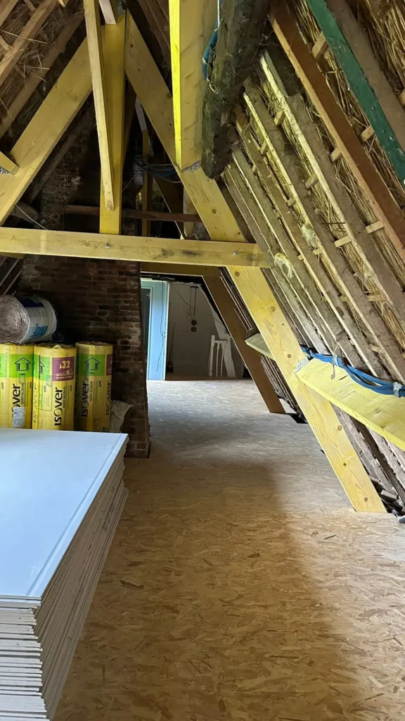 Combles en cours d'isolation avec plaques de plâtre stockées