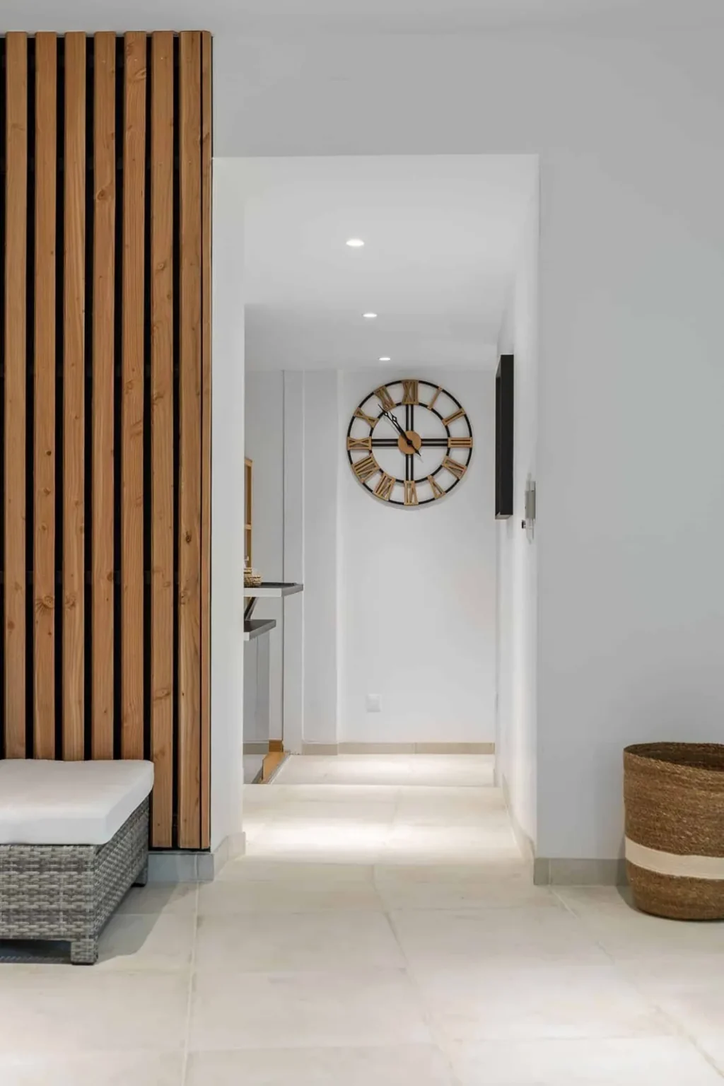 Entrée rénovée avec claustra en lames de bois et carrelage clair
