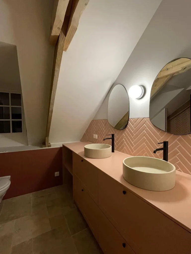 Salle de bains sous poutres avec meuble vasque terracotta et vasques en béton