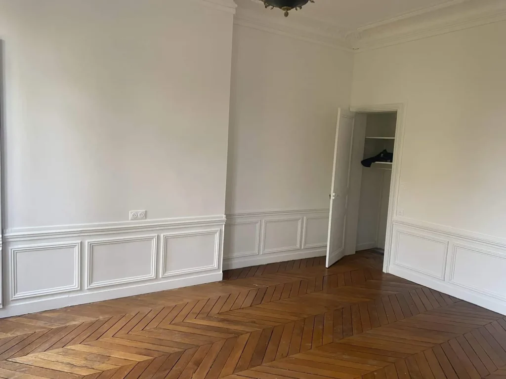 Pièce rénovée avec parquet en point de Hongrie et moulures